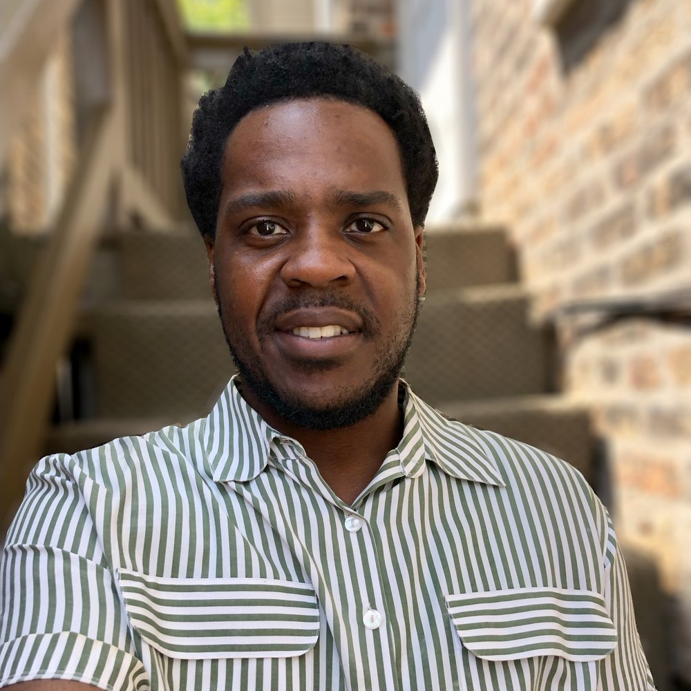 man in striped shirt gazes at camera