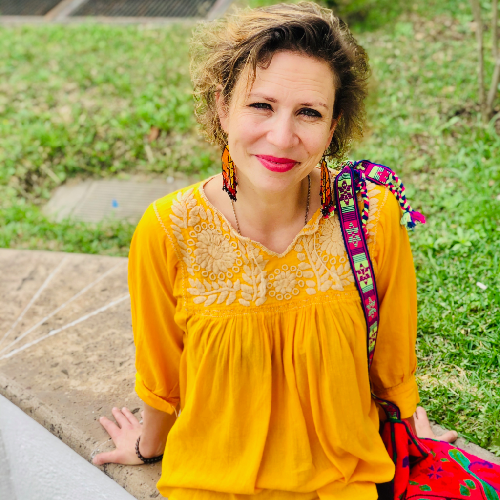 woman with vibrant yellow top gazes at camera