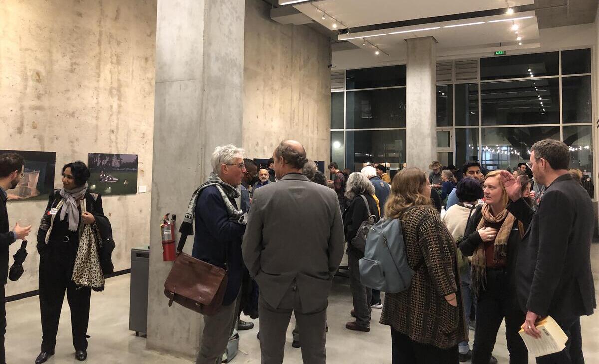Photo of the post-lecture reception held in the Brower Center gallery. The room is full of people standing, talking, and eating and drinking.