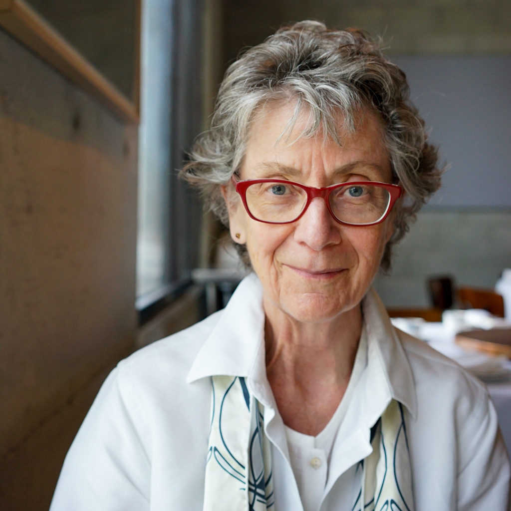 woman with glasses smiles at camera