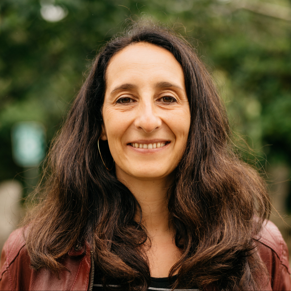 woman with long dark hair smiles at camera