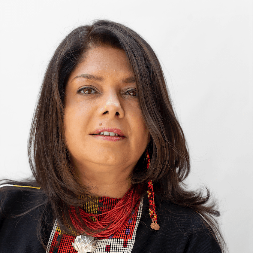 woman with bead necklace gazes at camera