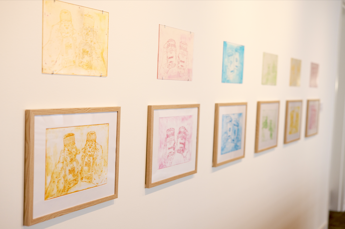 A photograph of a museum gallery wall with colorful images