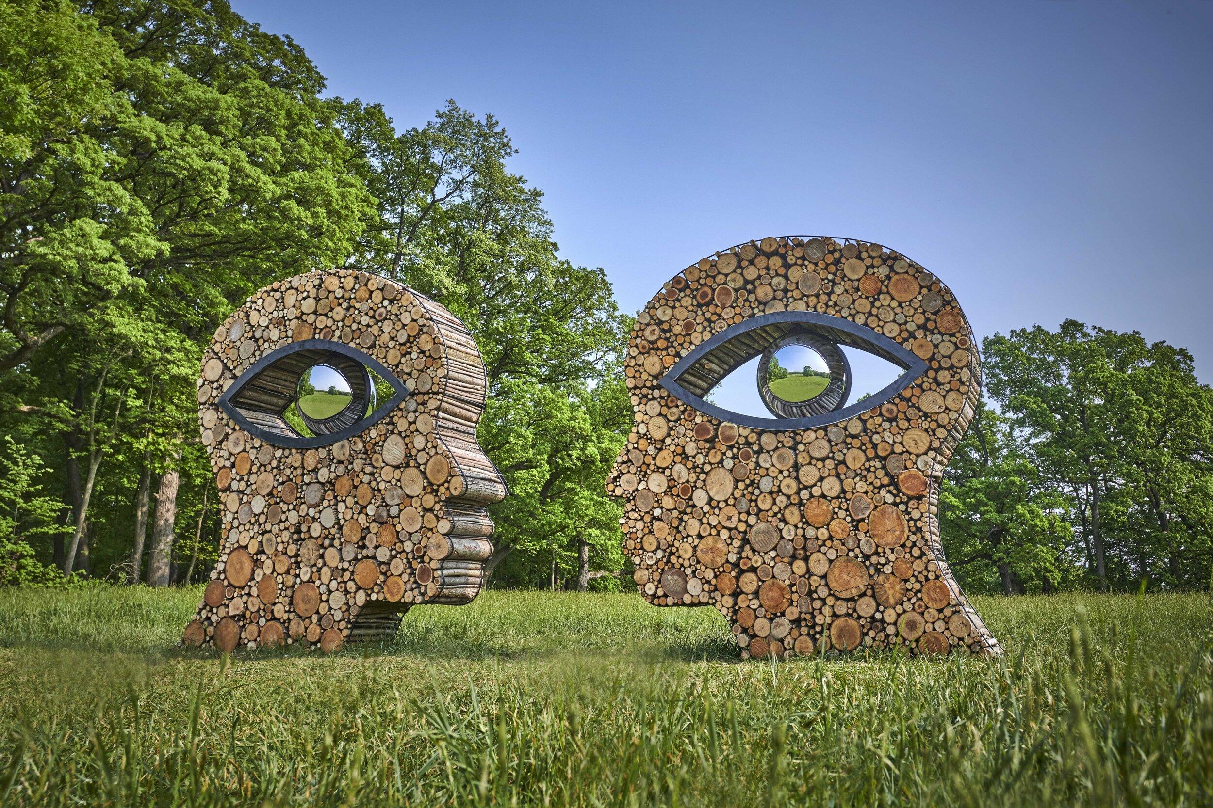 Photograph of an artwork made of reclaimed tree logs and branches