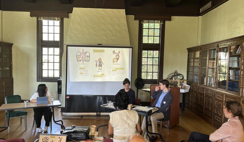 Scholars present information to a group of listeners.